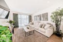 The living room features hardwood flooring, recessed lighting, and large windows with sheer and opaque curtains - 10936 117 Street, Edmonton, AB  - Indoor Photo Showing Living Room 