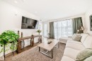The living space features hardwood flooring, recessed lighting, and large windows with sheer and solid curtains - 10936 117 Street, Edmonton, AB  - Indoor Photo Showing Living Room 