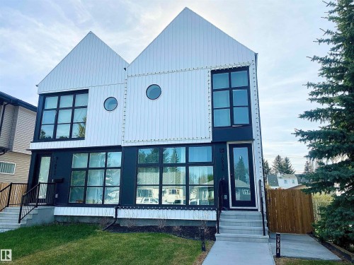 Contemporary duplex featuring a striking black and white facade with prominent gabled roofs - 10936 117 Street, Edmonton, AB - Outdoor