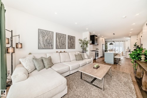 Open concept living space featuring recessed lighting, hardwood floors, and a kitchen with an island and stainless steel appliances - 10936 117 Street, Edmonton, AB - Indoor Photo Showing Living Room