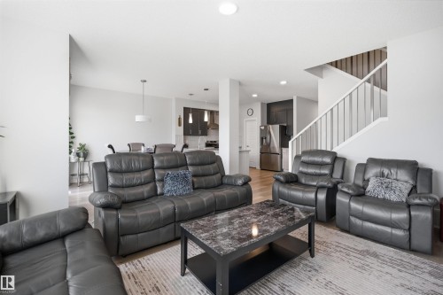 This open-concept living space features light-toned walls, recessed lighting, and hardwood flooring - 7017 54 Avenue, Beaumont, AB - Indoor Photo Showing Living Room