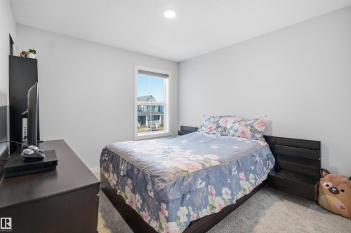 Bedroom featuring neutral-toned walls, a window providing natural light, and carpeting - 7017 54 Avenue, Beaumont, AB - Indoor Photo Showing Bedroom