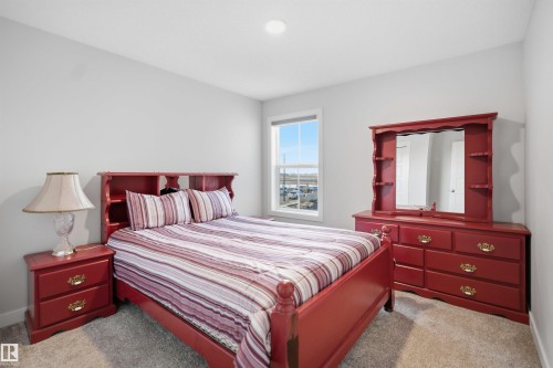 The room features light gray walls, a window providing natural light, and carpeting - 7017 54 Avenue, Beaumont, AB - Indoor Photo Showing Bedroom