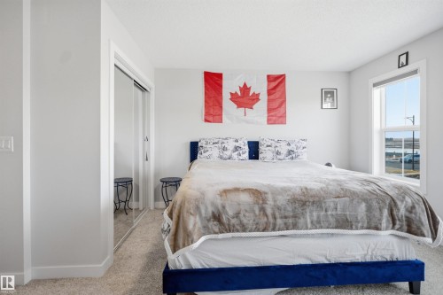 Bedroom featuring a window providing natural light and a closet with mirrored sliding doors - 7017 54 Avenue, Beaumont, AB - Indoor Photo Showing Bedroom