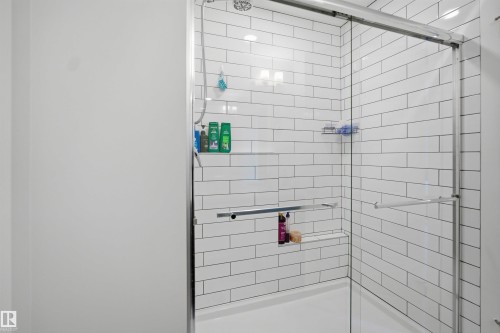 Shower with subway tile surround, clear glass enclosure, and an integrated shelf - 7017 54 Avenue, Beaumont, AB - Indoor Photo Showing Bathroom