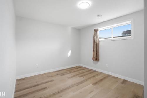 This room features light-colored walls and modern flooring - 7017 54 Avenue, Beaumont, AB - Indoor Photo Showing Other Room