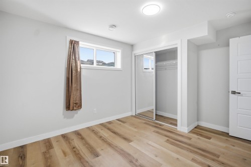 This room features light wood-look flooring, white walls, and a window for natural light - 7017 54 Avenue, Beaumont, AB - Indoor Photo Showing Other Room