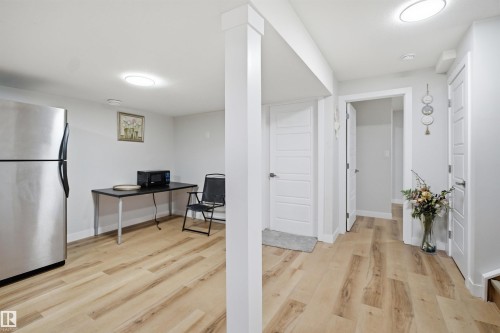 The property features light-toned wood flooring, recessed lighting, and white panel doors - 7017 54 Avenue, Beaumont, AB - Indoor