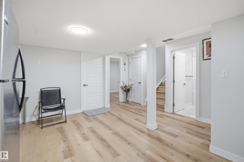This versatile space features light wood-style flooring, white walls, and a bright ceiling light fixture - 7017 54 Avenue, Beaumont, AB - Indoor Photo Showing Other Room