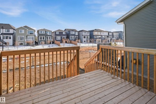 The property features a spacious wooden deck with railings and steps, offering outdoor living space - 7017 54 Avenue, Beaumont, AB - Outdoor With Exterior