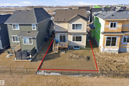 The property features a fenced yard, a rear deck, and a walk-out basement - 7017 54 Avenue, Beaumont, AB - Outdoor