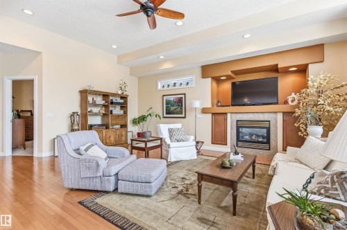 The living area features hardwood floors, recessed lighting, and a ceiling fan - 13 841 156 Street, Edmonton, AB - Indoor Photo Showing Living Room With Fireplace
