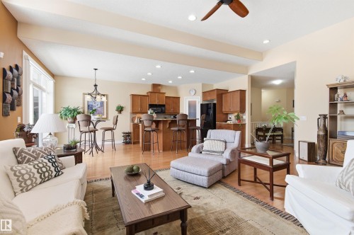 The spacious living area features high vaulted ceilings, light wood flooring, and an open-concept layout that incorporates a kitchen with wood cabinetry and a breakfast bar - 13 841 156 Street, Edmonton, AB - Indoor Photo Showing Living Room