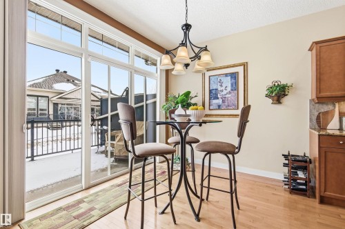 This dining area features hardwood floors and a sliding glass door providing access to the outside - 13 841 156 Street, Edmonton, AB - Indoor Photo Showing Other Room