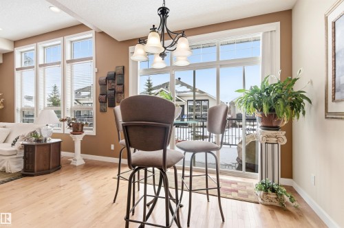 Open concept living area featuring light-toned hardwood flooring and a large sliding glass door - 13 841 156 Street, Edmonton, AB - Indoor