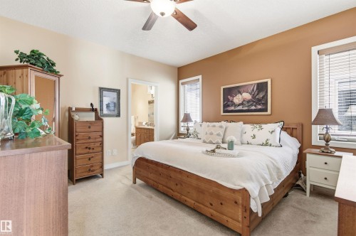 This room features neutral-toned carpeting, a ceiling fan, and two windows with blinds - 13 841 156 Street, Edmonton, AB - Indoor Photo Showing Bedroom