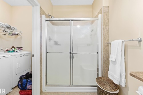The bathroom features a tiled shower with a sliding glass door and a shower head - 13 841 156 Street, Edmonton, AB - Indoor Photo Showing Bathroom
