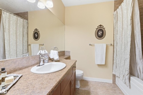Bathroom featuring a vanity with a countertop sink, a full-width mirror, and a bathtub with a shower curtain - 13 841 156 Street, Edmonton, AB - Indoor Photo Showing Bathroom