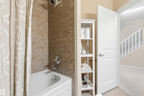 Bathroom featuring a white bathtub, shower with tile surround, and an adjacent open doorway - 13 841 156 Street, Edmonton, AB - Indoor Photo Showing Bathroom