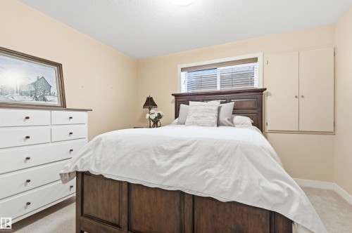 This room features light-colored walls and carpeting, a window with blinds, and built-in cabinetry - 13 841 156 Street, Edmonton, AB - Indoor Photo Showing Bedroom