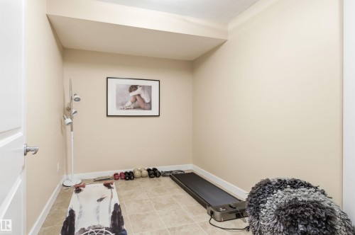 This versatile room features tiled flooring, neutral wall paint, and a white baseboard trim - 13 841 156 Street, Edmonton, AB - Indoor Photo Showing Other Room