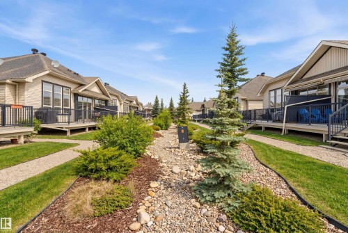 The property features a well-maintained exterior with tan siding and a dark roof - 13 841 156 Street, Edmonton, AB - Outdoor With Deck Patio Veranda