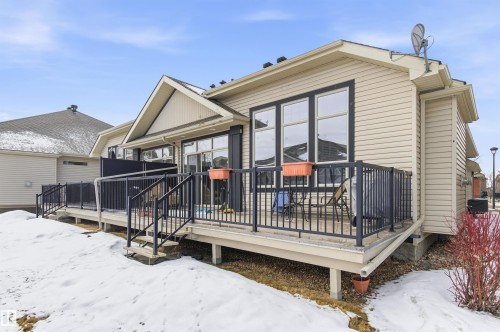 The property features an elevated rear deck with black railings and steps providing exterior access - 13 841 156 Street, Edmonton, AB - Outdoor
