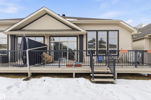 The property features an outdoor deck with black railings and a short staircase leading to the yard - 13 841 156 Street, Edmonton, AB - Outdoor With Deck Patio Veranda