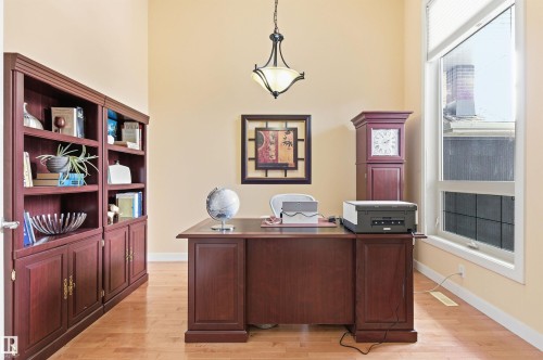 This room features a wooden desk, built-in shelving, and light-colored hardwood floors - 13 841 156 Street, Edmonton, AB - Indoor Photo Showing Office