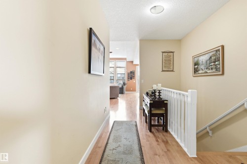 The property features a hallway with light hardwood flooring and neutral-toned walls - 13 841 156 Street, Edmonton, AB - Indoor Photo Showing Other Room
