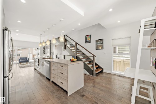 Open concept interior with hardwood floors and recessed lighting - 10607 127 Street, Edmonton, AB - Indoor Photo Showing Kitchen With Upgraded Kitchen