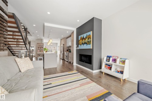 The main living area features hardwood floors throughout and recessed lighting - 10607 127 Street, Edmonton, AB - Indoor Photo Showing Living Room With Fireplace