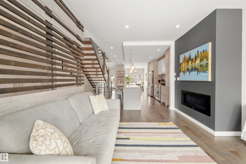 Living area with hardwood flooring, a modern fireplace, and recessed lighting - 10607 127 Street, Edmonton, AB - Indoor With Fireplace