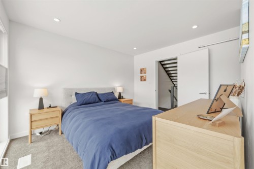 The property features a bright room with recessed lighting, light-colored walls, and carpeted flooring - 10607 127 Street, Edmonton, AB - Indoor Photo Showing Bedroom