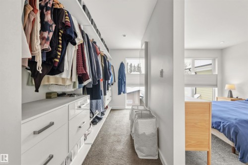 The property features a spacious closet with built-in storage, including shelving and drawers with dark hardware, and a carpeted floor - 10607 127 Street, Edmonton, AB - Indoor With Storage