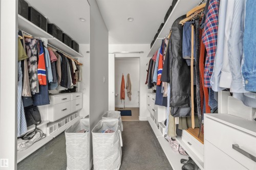 The property features a walk-in closet with extensive built-in shelving, hanging rods, and drawers for organization - 10607 127 Street, Edmonton, AB - Indoor With Storage