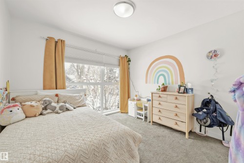 This room features a large window with blinds and curtains, offering views of the outdoors - 10607 127 Street, Edmonton, AB - Indoor Photo Showing Bedroom