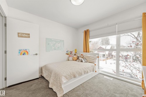 This room features a large window with white blinds and yellow curtains, offering views of the outdoors - 10607 127 Street, Edmonton, AB - Indoor Photo Showing Bedroom