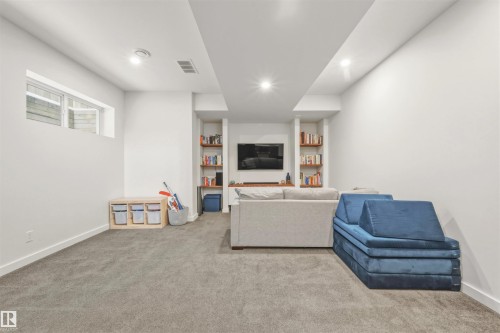 Spacious carpeted room featuring recessed lighting, a window, and built-in shelving - 10607 127 Street, Edmonton, AB - Indoor