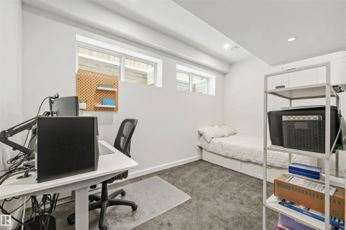 This room features white walls, carpeted flooring, and two windows providing natural light - 10607 127 Street, Edmonton, AB - Indoor Photo Showing Office