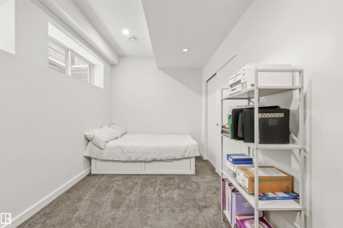 The room features white walls, grey carpet, and a window providing natural light - 10607 127 Street, Edmonton, AB - Indoor Photo Showing Bedroom