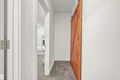 The property features a hallway with light gray carpeting and white walls - 10607 127 Street, Edmonton, AB - Indoor