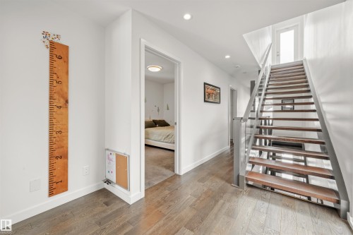 This hallway features hardwood flooring, white walls, and recessed lighting - 10607 127 Street, Edmonton, AB - Indoor Photo Showing Other Room