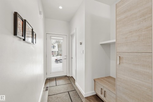 Entryway featuring light-colored wood-look cabinetry with silver hardware, a built-in bench with storage, and a shelf - 10607 127 Street, Edmonton, AB - Indoor Photo Showing Other Room