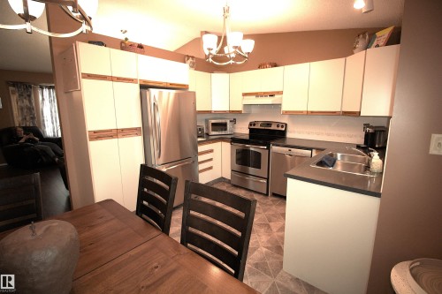The kitchen features white cabinetry, stainless steel appliances, and dark countertops - 9347 175 Avenue, Edmonton, AB - Indoor Photo Showing Kitchen With Double Sink