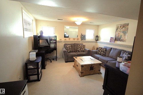 This spacious room features neutral-toned walls and carpeted flooring, creating a versatile living space - 9347 175 Avenue, Edmonton, AB - Indoor Photo Showing Living Room