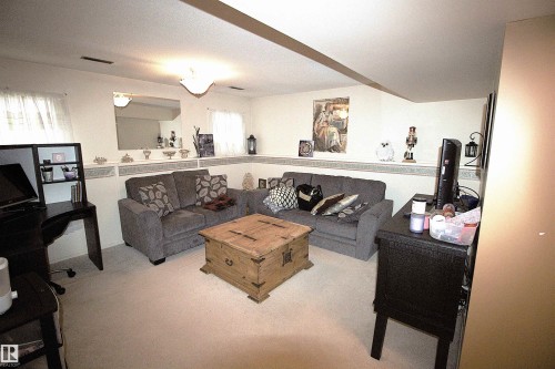 This versatile room features light-colored carpeting, white walls, and a ceiling light fixture providing illumination - 9347 175 Avenue, Edmonton, AB - Indoor With Fireplace