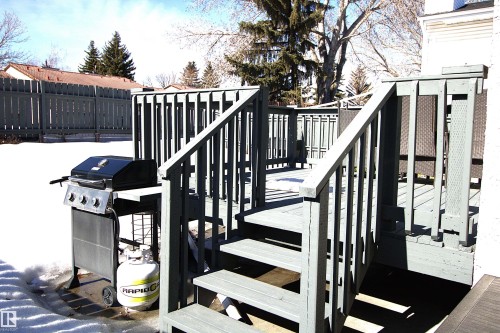 The property features an outdoor deck with stairs, surrounded by a wooden fence - 9347 175 Avenue, Edmonton, AB - Outdoor