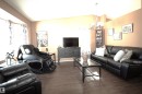 The living area features wood-look flooring, a chandelier, and a bay window - 9347 175 Avenue, Edmonton, AB  - Indoor Photo Showing Living Room 