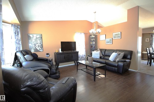 The living area features vaulted ceilings, hardwood flooring, and a chandelier light fixture - 9347 175 Avenue, Edmonton, AB - Indoor Photo Showing Living Room